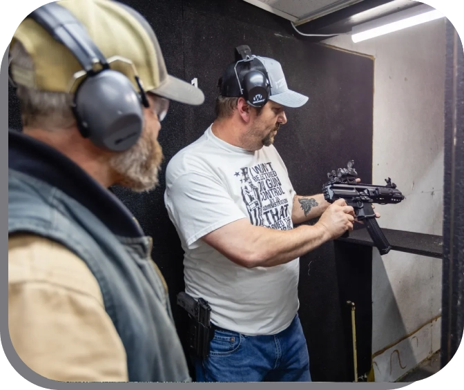 Two men are holding guns in a gun range.