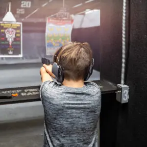 A man is holding his gun up to the side of his face.