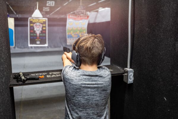 A man is holding his gun up to the side of his face.