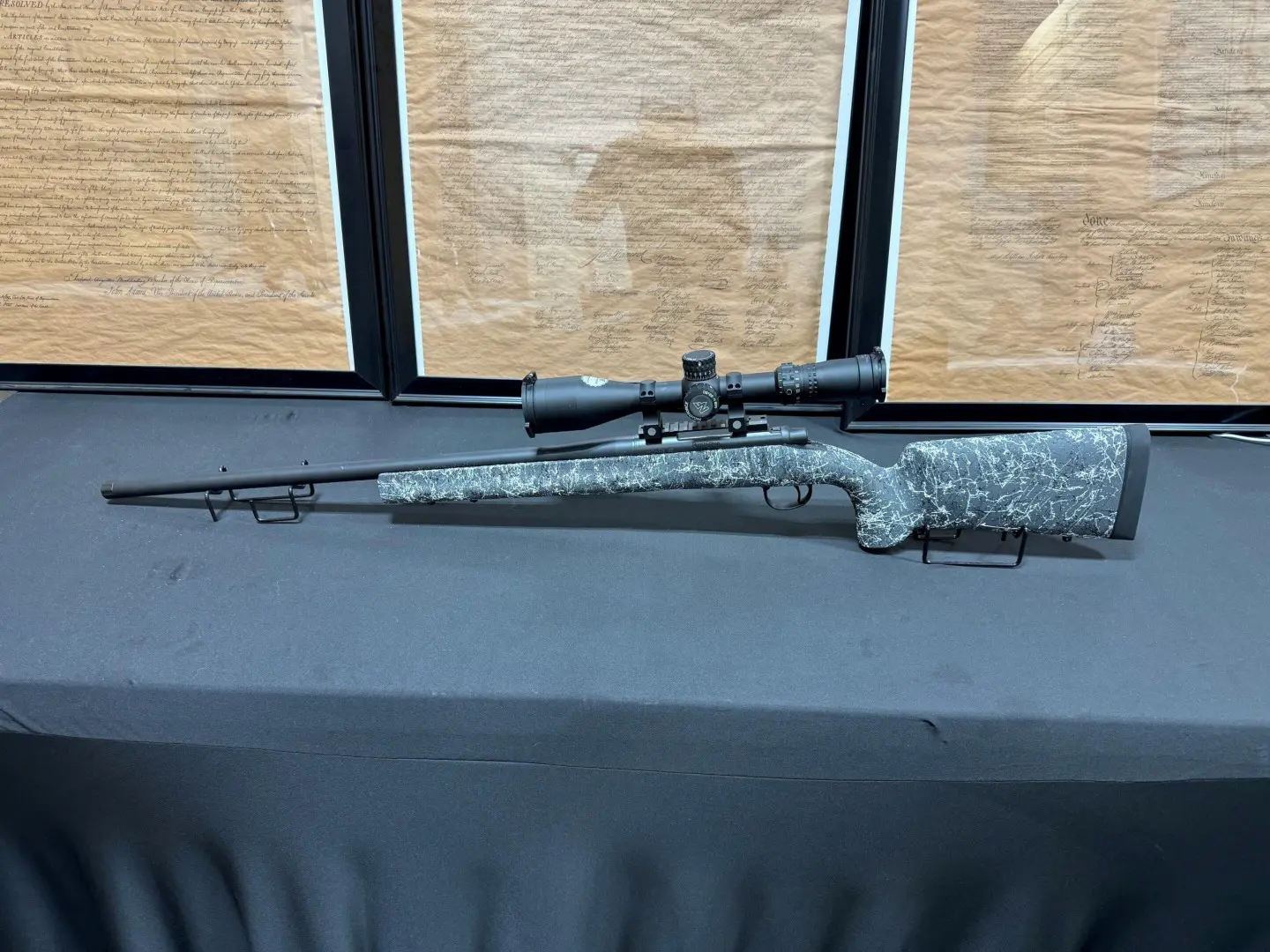 A closeup look at a sniper riffle kept on a table